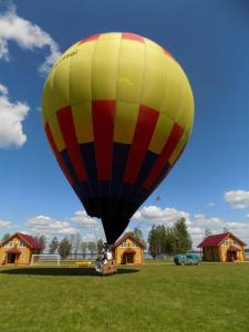 a yellow and red hot air balloon in a field at Woods Lake Resort in Potashëvo