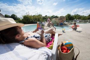 a young girl laying on a chair next to a swimming pool at Camping Du Port De Plaisance in Péronne +25 photos