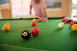 a woman playing a game of pool on a pool table at Camping Du Port De Plaisance in Péronne