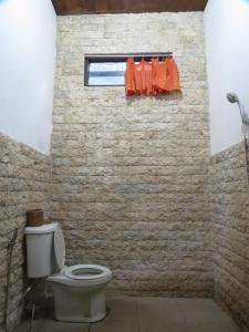 Un baño con inodoro blanco y ventana. en Lemon House, en Padangbai