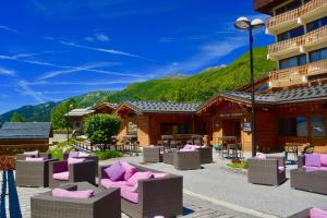 a resort with purple chairs and a building at La Perelle in Saint-François-Longchamp