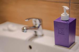 ヤロスワビエツにある4 strony świataの紫色の歯ブラシホルダー(バスルームの洗面台に座る)