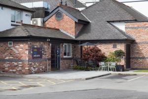 a brick building with a patio with tables and chairs at Hello Hotel in Manchester