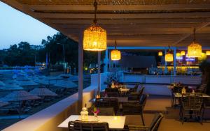 アキアーラにあるLIV Hotel by Bellazureのテーブル、椅子、照明付きのレストラン