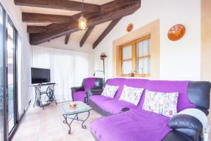 ein Wohnzimmer mit einem lila Sofa und einem TV in der Unterkunft Sa Tanca -Mancorina- in Mancor del Valle