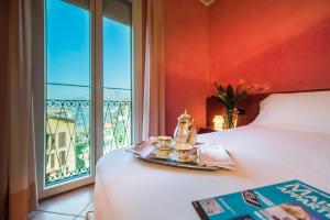 a hotel room with a bed with a tray with tea cups at Hotel San Gerolamo in Vercurago