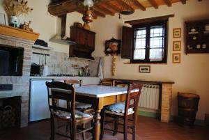 a kitchen with a table and chairs and a fireplace at La Moiana in San Quirico dʼOrcia