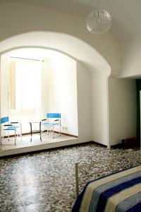 カザラーノにあるPalazzo Galloの椅子2脚、テーブル、窓が備わる客室です。