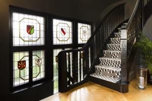 einen Flur mit einer Treppe mit Buntglasfenstern in der Unterkunft Boutique Hotel Des XV in Straßburg