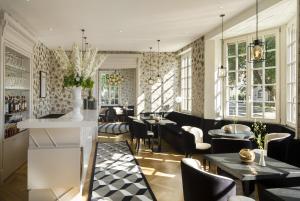 a restaurant with tables and chairs and windows at Boutique Hotel Des XV in Strasbourg