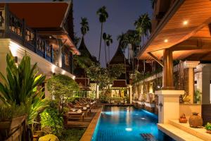 een zwembad in het midden van een gebouw met een resort bij Davis Thai House in Bangkok