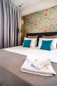 two beds in a room with blue pillows at Nayino Resort Hotel in Mamaia Nord