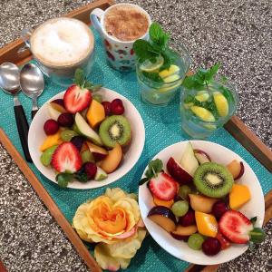 três pratos de fruta num tabuleiro sobre uma mesa em Glamping Byron Bay em Rosebank