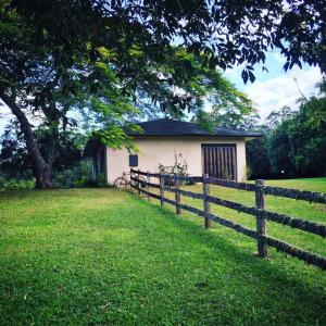 a house in a field with a fence at Glamping Byron Bay in Rosebank