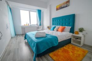 ママイアにあるRelax Apartmentのベッドルーム1室(大型ベッド1台、青いヘッドボード付)
