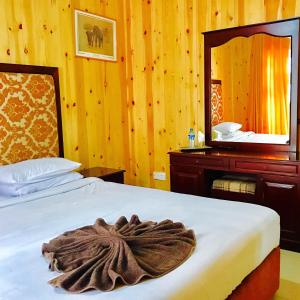a hotel room with a bed with a large mirror at Single Tree Hotel in Nuwara Eliya