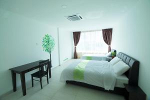 a bedroom with a bed and a desk and a window at Hard Rock VIP Guest House in Mersing