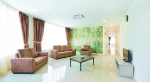 a living room with two couches and a tv at Hard Rock VIP Guest House in Mersing