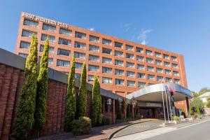 un edificio di mattoni rossi con alberi di fronte di Best Western Plus Launceston a Launceston