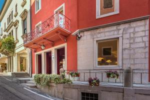 - un bâtiment rouge avec balcon dans une rue dans l'établissement Hotel San Daniele, à San Daniele del Friuli