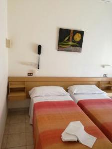 una camera d'albergo con due letti e asciugamani di Hotel AnnaMare a Rimini
