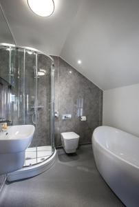 a bathroom with a sink and a tub and a toilet at Black Bull Inn, Moffat in Moffat