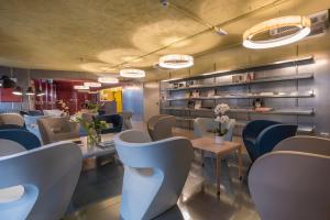 a restaurant with white chairs and tables and shelves at Hotel San Daniele in San Daniele del Friuli