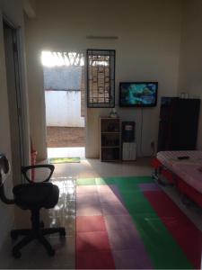 a room with a room with a chair and a television at Olivine House in Bandar Lampung