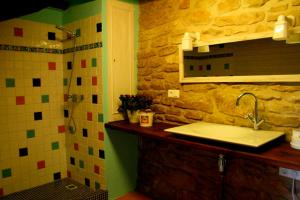 a bathroom with a sink and a stone wall at Les Cavallerisses in Guialmons