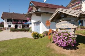 a sign in front of a building with flowers at Ferienhaus Bergwald in Bodenmais