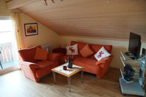 ein Wohnzimmer mit einem orangenen Sofa und einem Tisch in der Unterkunft Ferienhaus Bergwald in Bodenmais