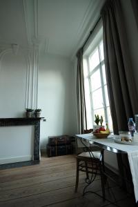 a living room with a table and a window at B&B Alice & Anaïs in Bruges