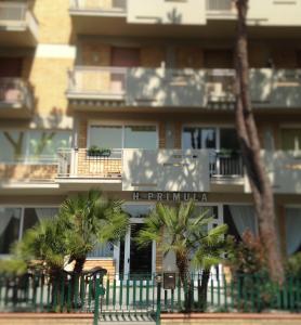 a building with palm trees in front of it at Hotel Primula in Lido di Savio