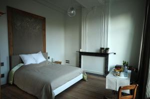 a bedroom with a bed and a fireplace and a table at B&B Alice & Anaïs in Bruges