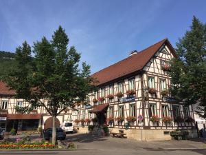 un grand bâtiment avec des fleurs devant lui dans l'établissement Hotel Ristorante Rostica, à Bad Urach