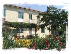 a building with a lot of flowers in front of it at Agriturismo La Rondine in Bolgheri
