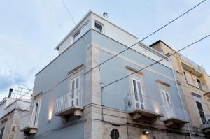 un edificio blanco con balcones en un lateral en La casa dei colombi, en Ruvo di Puglia