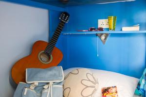 a guitar and a bag and a chair in a room at Marco Polo Party Hostel in St. Julianʼs