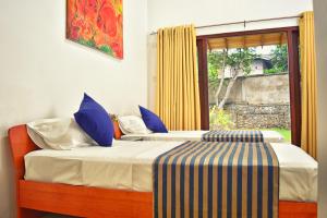 2 camas en una habitación con ventana en Volunteer Ceylon, en Ratnapura