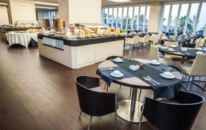 a restaurant with tables and chairs and a buffet at Melia Madeira Mare in Funchal
