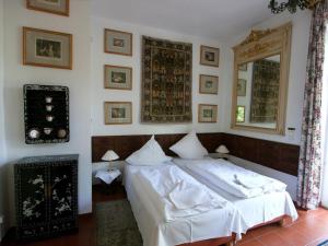una camera da letto con un letto con lenzuola bianche e uno specchio di Rittergut Haus Laer a Bochum