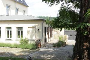 ein weißes Haus mit einem Baum davor in der Unterkunft Ferienwohnung an der Elbe in Dresden