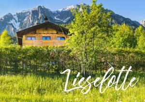 drewniany dom na polu z górami w tle w obiekcie Apartmenthaus Lieselotte w mieście Ramsau am Dachstein