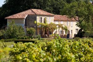 an old stone house in a garden with trees at Logis L'Auberge de Larressingle in Larressingle
