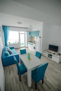 ママイアにあるRelax Apartmentのリビングルーム(テーブル、青い椅子付)