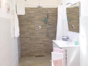 a bathroom with a shower with a wooden wall at Appartamento La Pinetina in Valderice