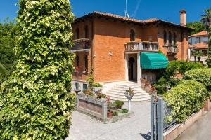 Casa de ladrillo grande con porche y balcón. en Villa Albertina, en Lido de Venecia