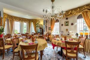 un ristorante con tavoli, sedie e lampadario a braccio di Villa Albertina a Lido di Venezia