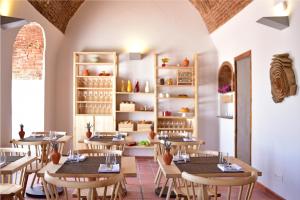 a restaurant with tables and chairs in a room at Noble House Essence Évora - by Unlock Hotels in Évora