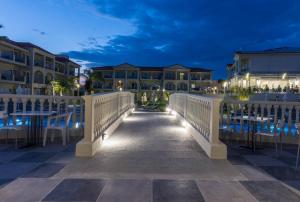 un pont menant à un complexe la nuit dans l'établissement Exotica Hotel & Spa by Zante Plaza, à Kalamaki